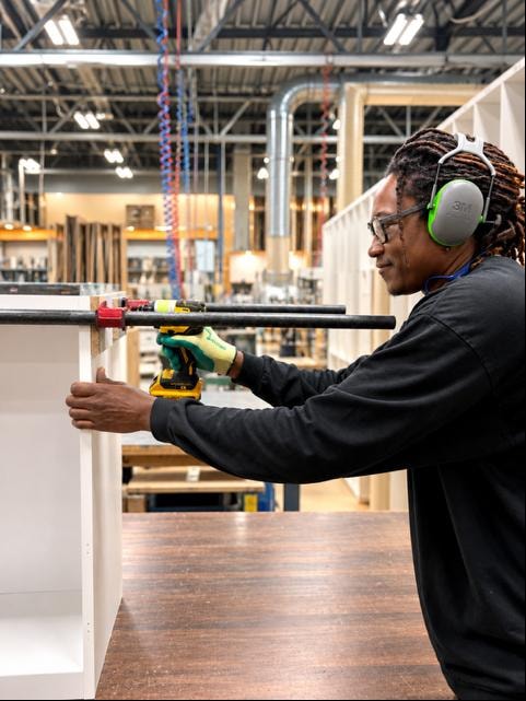 Ébéniste assemblant un meuble en atelier Module Ultra