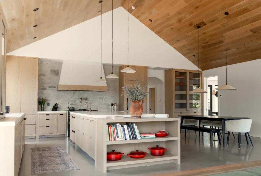Cuisine en bois naturel avec plafond cathédrale et îlot central